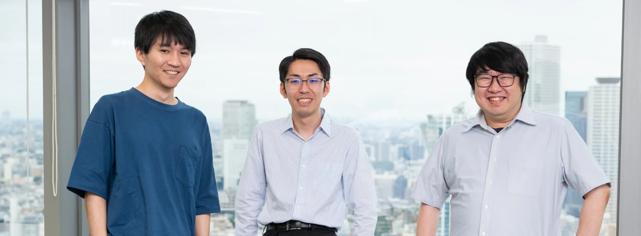 オフィスの窓際で談笑するTDSE社員